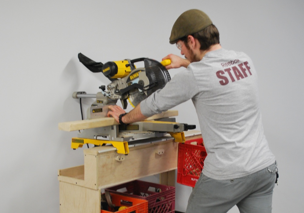 The rail along the top of the cart fits the mounting brackets of a Dewalt miter saw for transportation and use.